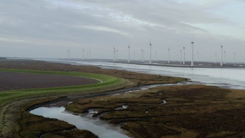 Windfarm near tidal area and dyke protecting adjacent polder from sea