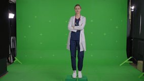 Young female doctor wear medical uniform over green screen background, Young caucasian woman spins in place . Chroma Key 4k raw video footage
