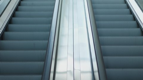 Fronview and slow motion of two metal escalator is moving up and down to in department store or train station with beautiful sun light, it shows concept of transportation for urban life in the city.