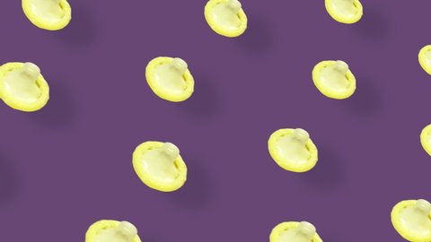 Colorful pattern of condoms on violet background with shadows. Seamless pattern with condom. Top view. Realistic animation. 4K video motion