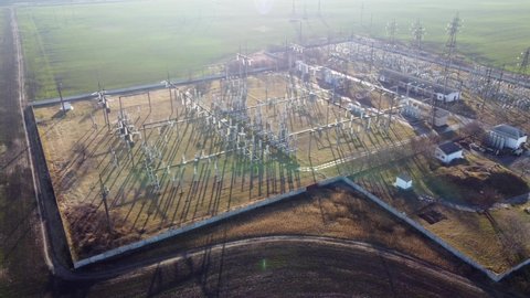 Transformer electrical power plant. Electric transmission substation with metal poles and electrical wires. High voltage power station. Pylons and voltage distribution cables. Transformation station