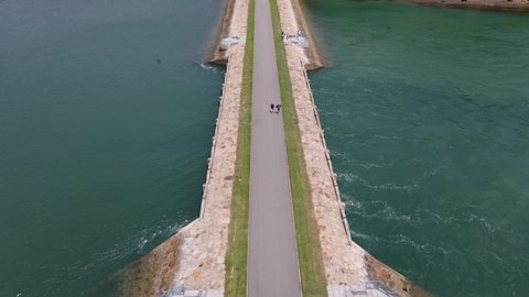 Bridge Over Calm Sea With Beach And Lush Green Forest At Lazarus Island In Singapore. - aerial dolly in