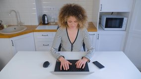 Focused freelancer woman working on laptop computer at home during lockdown. Beautiful young adult female typing on notebook pc. Attractive white person doing freelance work online in 4k stock video
