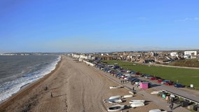 Wide shingle beach with esplanade at Seaford in East Sussex England, Aerial Footage.