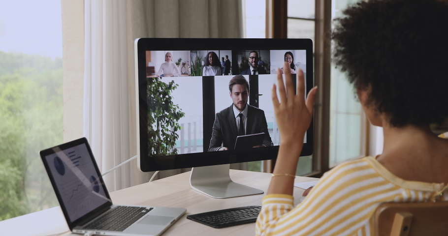 Diverse business partners take part in video call, pc monitor view over shoulder of African businesswoman. Company briefing, group brainstorm, virtual meeting through videoconference, teamwork concept Royalty-Free Stock Footage #1085933969