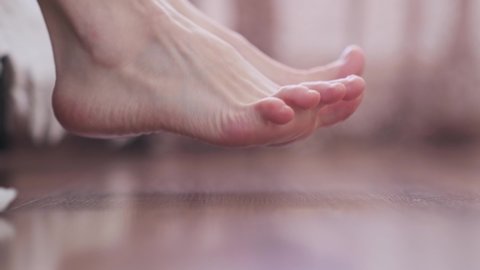 Bare feet on the floor, close-up. Morning warm-up for the legs. Selective focus, blurred background, bokeh.