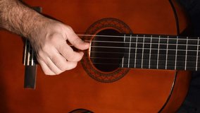 a man plays the guitar in close-up