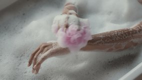 Young african american lady washing her smooth body with sponge and soap, taking hot soapy bath at home, top view, tracking shot, slow motion - Powered by Shutterstock - Get 15% off with code: PIKWIZARD15