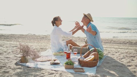romantic couple in hats walking along sandy beach holding hands. love and happiness moments. Valentines day in sea travel.