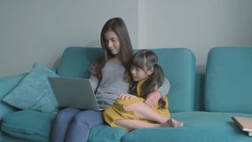 homeschooling and online study concept.Mother and daughters are learning online at home.Asian girl and her teacher using laptop for online study during homeschooling at home.