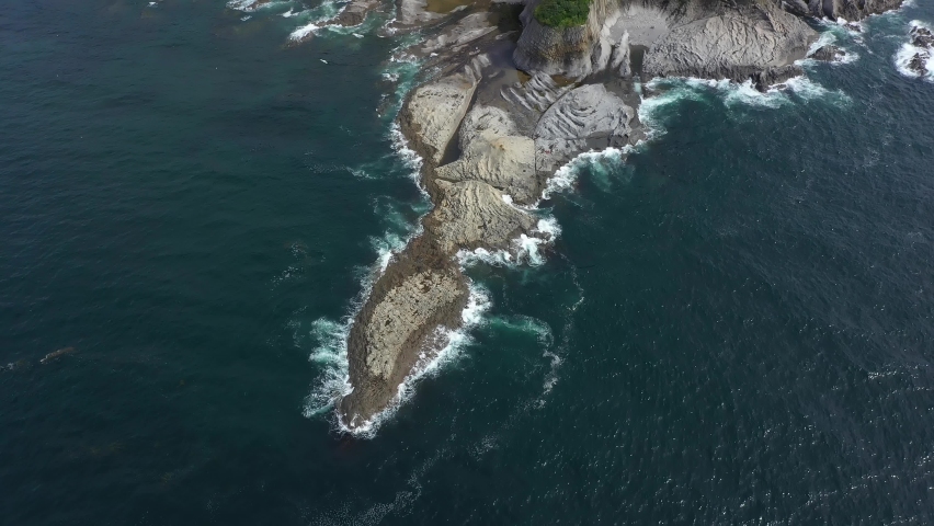 Flying Over the Cape Stolbchaty, Volcanic Rock Formation on Kunashir island, Lesser Kuril Chain, Russia. Royalty-Free Stock Footage #1085953589