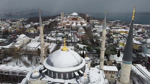 Istanbul, Turkey - January 23, 2022: Aerial panoramic view of Hagia Sophia, background, and the Blue mosque during a heavy snowfall in Istanbul.