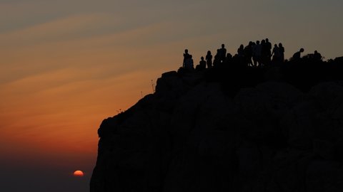 people watch a beautiful sunset at Belvedere (lookout point ) Foradada at Capo Caccia. Alghero, Sassari, Sardinia, Italy, Europe