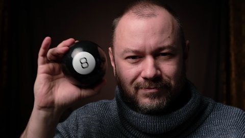 Billiard prediction ball. A middle-aged man is looking for answers. Ball eight.