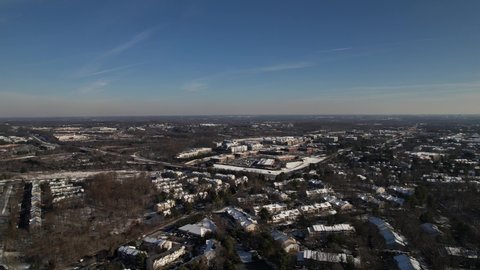 Germantown, Maryland, USA - Jan. 3, 2022: An aerial view of a residential suburban neighborhood blanketed in snow. Interstate 270 is visible in the distance.
