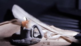 Vintage candle with parchment paper and writing quill medium shot selective focus - Powered by Shutterstock - Get 15% off with code: PIKWIZARD15