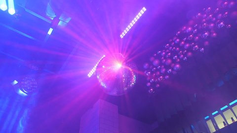 Rays of light reflecting from the disco ball, illuminate the smoke. Disco Ball Spinning seamless with Flares