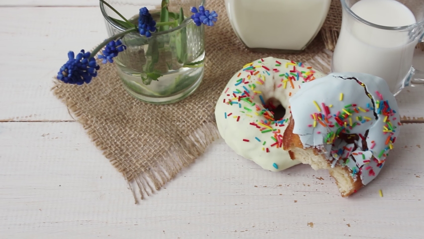 Bright tasty donuts covered with icing and powder. Donuts and milk for breakfast