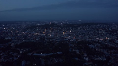 Night aerial drone video of city Lviv, Ukraine. Flight above house roofs and streets. Panorama of ancient popular central part of old European town Lvov, Ukraine. Rynok Square, Central Hall, Ratusha