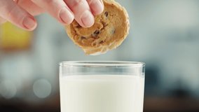 Eating cookie with milk in glass cup close-up. Glass with yogurt, dairy products concept. Drinking fresh lactose-free milk in morning. - Powered by Shutterstock - Get 15% off with code: PIKWIZARD15
