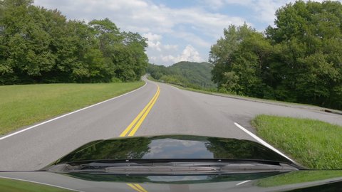 Driving a passenger vehicle going up on asphalt road in Great Smoky Mountains, Tennessee. Summer day