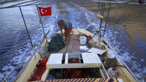 4K.Turkish fisherman people goes by boat at sea in Turkey.Fish nets on a small fishing ship.Vessel human coastline seaboard beach coast seaside shore seashore waterside littoral ocean jagged marine