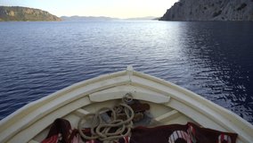 4K.The bow of a white wooden boat sailing on the sea.A thick rope in front of the small ship.Vessel passing a narrow bay at slow speed.Coastline gulf inlet cove seaboard coast seaside shore seashore - Powered by Shutterstock - Get 15% off with code: PIKWIZARD15