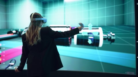 Automotive Engineer Using a VR Software to Showcase Electric Motor and Vehicle Platform in Interactive Environment. Female Engineer Using Virtual Reality Headset and Controllers for Her Project.