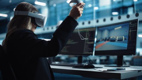 Industrial Software Developer Writing Code and Testing Automotive Manufacturing Interface. Engineer Editing Electric Motor and Car Chassis while Wearing Virtual Reality Headset and Using Controllers.