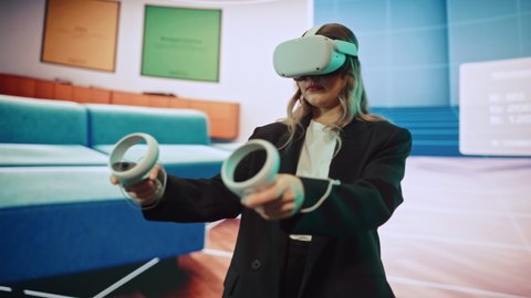 Interior Designer Using a VR Software to Design a Home, Try Different Colors, Move Furniture in Interactive Environment. Female Engineer Using Virtual Reality Headset and Controllers for Her Project.