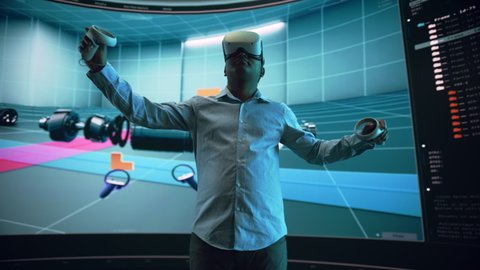 Automotive Engineer Using a VR Software to Showcase Electric Motor and Vehicle Platform in Interactive Environment on a Big Digital Screen. Multiethnic Male Engineer Using Headset and Controllers.