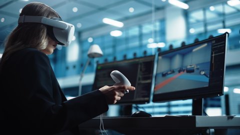 Automotive Engineer Using a VR Software to Work on Electric Motor and Vehicle Platform in Interactive Environment in a Factory Office. Industrial Engineer Using Headset and Controllers. 库存视频