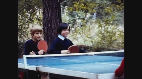 PAVIA, ITALY JUNE 1962: Italy 1962, Children play ping pong in the garden in 60s