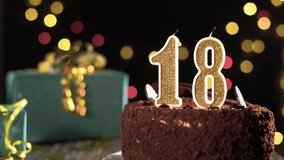 Birthday candle number eighteen on a sweet cake on the table, 18th birthday. Fire from a lighter, blow out a festive candle. - Powered by Shutterstock - Get 15% off with code: PIKWIZARD15