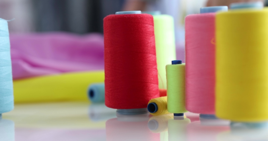 Multi-colored threads and fabrics in workplace closeup