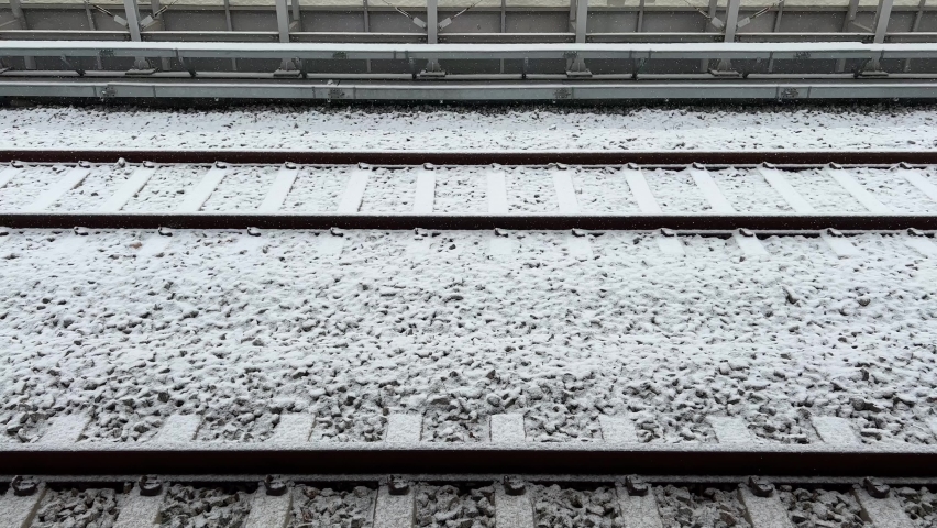 Snow is falling on the railroad track