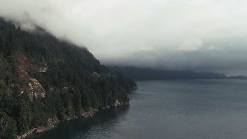 Misty Clouds Over Tranquil Seascape And Dense Forest Mountains In British Columbia, Canada. Wide Shot