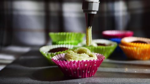 Decorating cupcakes with icing and piping bag medium dolly slow motion shot selective focus