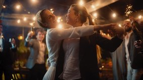 Beautiful Happy Lesbian Couple Celebrate Wedding at an Evening Reception Party with Diverse Multiethnic Friends. Queer Newlyweds Dancing and Kissing at a Restaurant Venue. LGBTQ Relationship Goals. - Powered by Shutterstock - Get 15% off with code: PIKWIZARD15