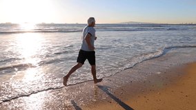 64 year old man getting his exercise at the beach at sunset. Slow Motion. - Powered by Shutterstock - Get 15% off with code: PIKWIZARD15