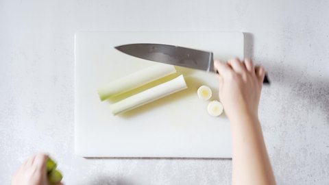 cut a leek on the kitchen table with a chef's knife