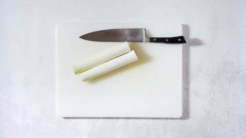 cut a leek on the kitchen table with a chef's knife