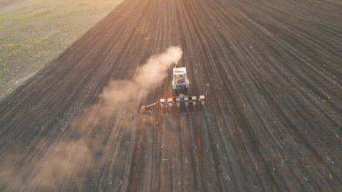  aerial view of Farmer with old tractor seeding sowing crops at agricultural fields in spring in poor countries. cultivation of land. Farmers preparing land and fertilizing. Agricultural