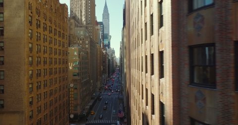 Стоковое видео: Horizontally fly along decorated brick wall. Sliding reveal of busy Lexington avenue lined by large buildings. Manhattan, New York City, USA