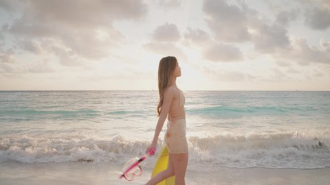 Asian young women in swimsuits walking on the beach with diving equipment at sunset. Summer vacation at sea for a happy female.
Young adult woman who is carefree and freedom.