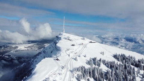 Aerial drone footage of the Rigi mountain summit with its train station above lake Lucerne in the alps in winter in Switzerland