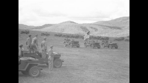 CIRCA 1940s - American soldiers drive jeeps towing artillery pieces across an open field.