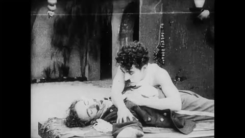 CIRCA 1915 - In this silent comedy, a soldier (Charlie Chaplin) mourns the death of his friend while peasants try to break into their fort.