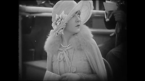CIRCA 1925 - In this silent film, high society people check their programs at a racetrack.