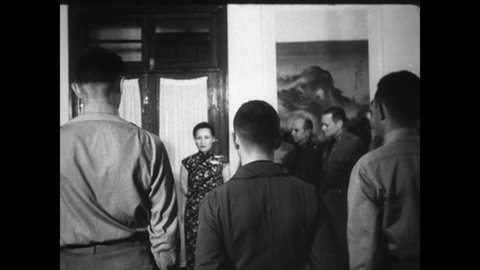 CIRCA 1940s - Madame Chiang Kai-Shek decorates American soldiers.